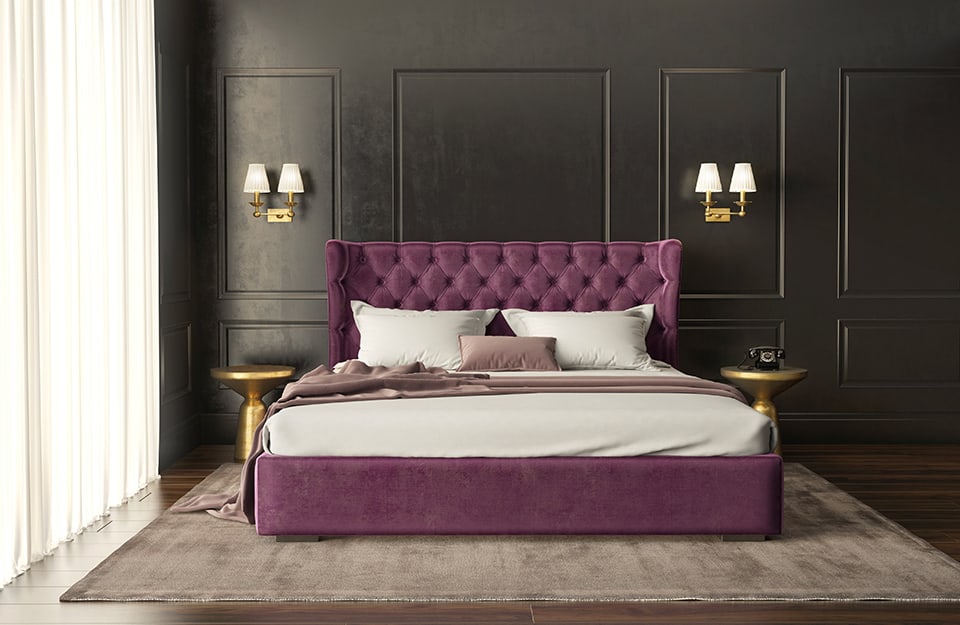 Dormitorio grande con paredes enmarcadas en negro, apliques dobles de metal dorado a cada lado de la cama, cabecero acolchado morado, mesillas metálicas, alfombra grande debajo de la cama, suelo de parqué y cortina blanca cubriendo la ventana;