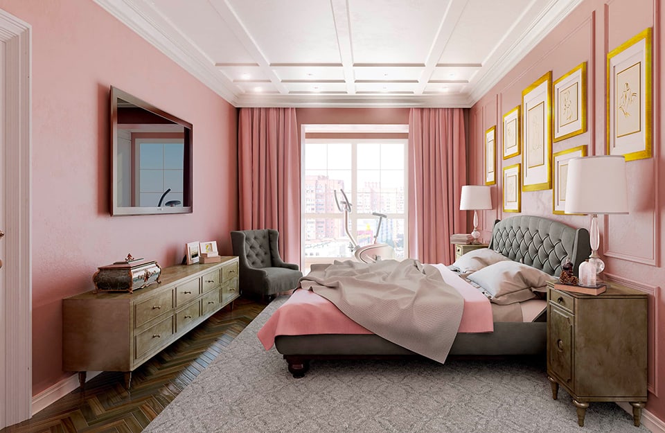 Ampia camera da letto con pareti rosa, vista dal lato. Le pareti sono decorate con cornici, così come il soffitto, bianco. A terra un parquet scuro e, sotto il letto, un grande tappeto grigio. Il letto ha una struttura imbottita grigia e la testiera pure imbottita dello stesso colore. La biancheria del letto è grigia e rosa. Ai lati del letto due comodini in stile classico con sopra lampade, libri e oggetti. Sulla parete sopra al letto dei quadri in cornici gialle. Sulla parete opposta una grande tv appesa al muro e sotto una consolle classica con molti cassetti e soprammobili. In fondo alla stanza c'è una finestra che dà su un panorama urbano. Le tende sono rosa come le pareti e davanti alla finestra c'è una cyclette