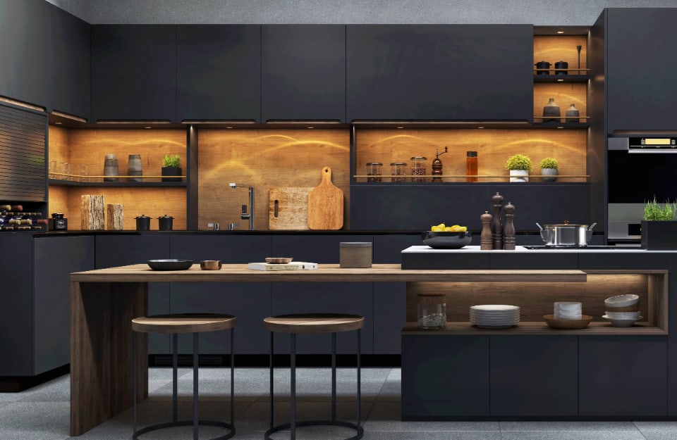 Grande cucina nera di un open space, con mobili con nicchie color legno illuminate e con isola e tavolo da pranzo incorporato 