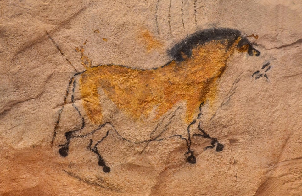 Una pittura rupestre di un cavallo, disegnata con nero carbone e ocra