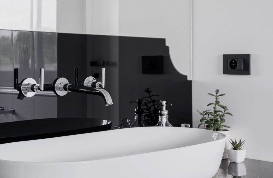 Dettaglio del lavabo di un bagno moderno arredato in stile glam con cornici decorative