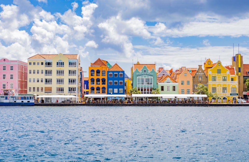 Front view of the colourful buildings in Willemstad, Curaçao, overlooking the canal that divides the city 's two historic districts