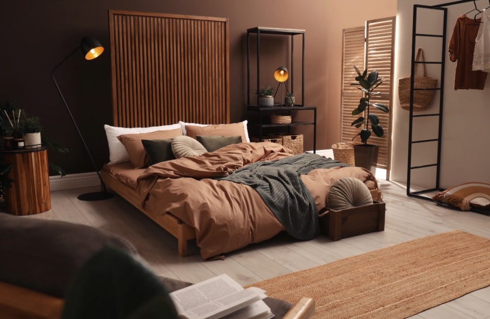 Camera da letto accogliente e moderna,  dominata da nuance terrose come il terracotta, il caramello e il marrone cioccolato, abbinate a tocchi di verde bosco e beige, con materiali come il legno, il rattan e il lino